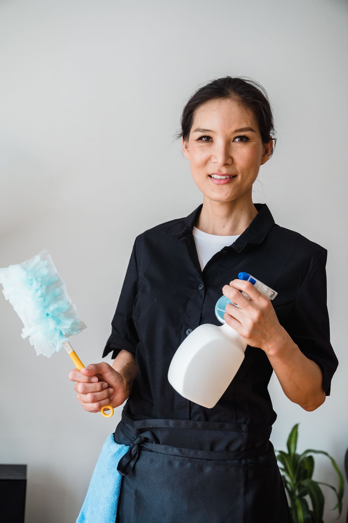 掃除道具を持つ笑顔の女性